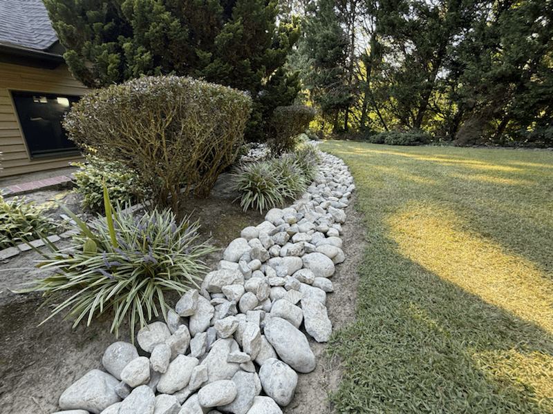 Decorative river rock border beside a home